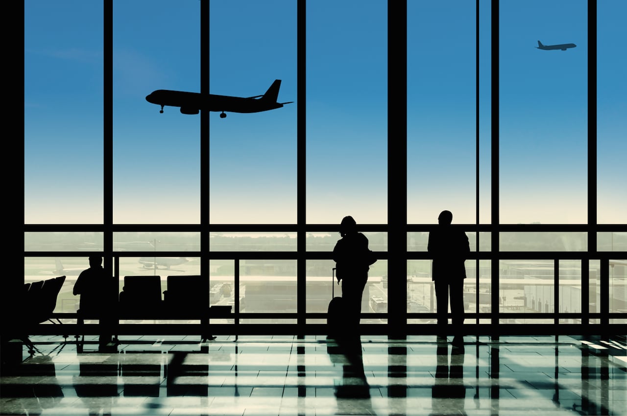 Passeggeri in un terminal aeroportuale dove si formano code al check-in e ai controlli di sicurezza
